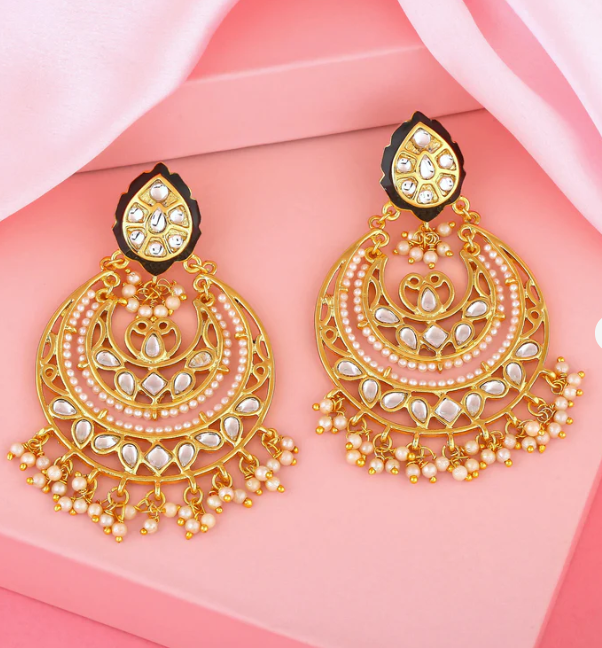 Woman wearing oversized gold statement earrings, 2025 jewelry fashion trend