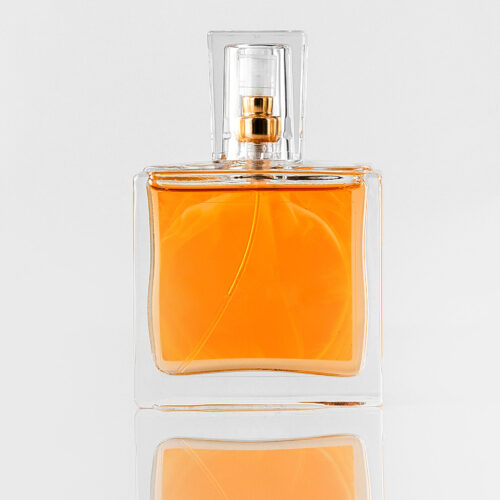 front-view-orange-perfume-inside-glass-isolated-white-floor